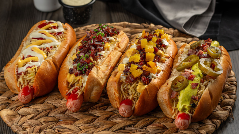 four hot dogs, each with different toppings