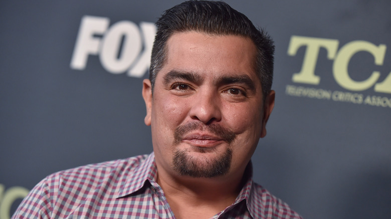 Aarón Sánchez smiling at event in a check shirt