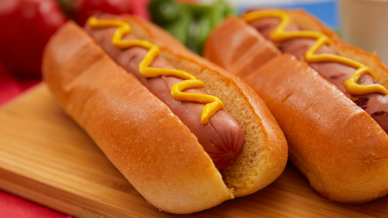 Close-up of two hot dogs with a swirl of mustard on top