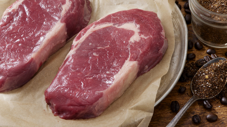 Raw steaks on parchment paper