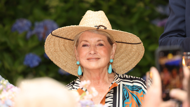 Martha Stewart smiling, wearing a large straw hat