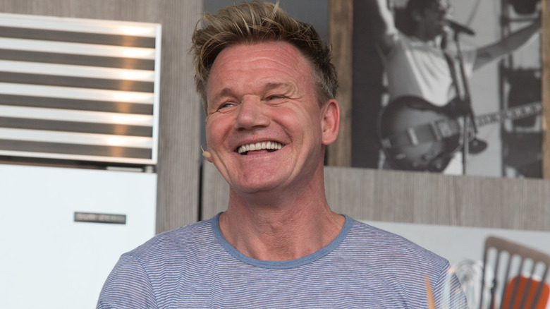 Gordon Ramsay smiles and laughs in a kitchen