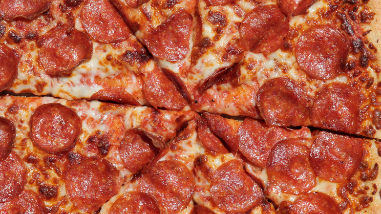 Slices of pepperoni pizza all together in a single pie