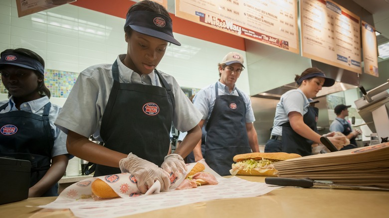 Worker making a Jersey Mike's sub.