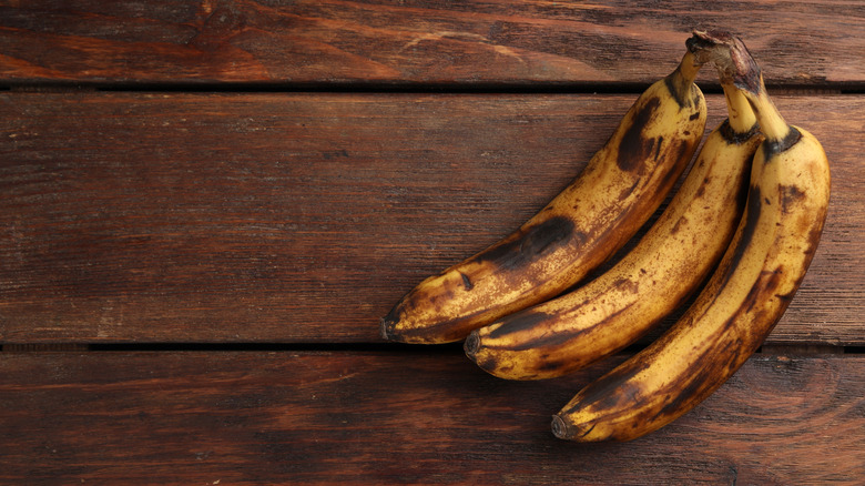 Ripe bananas sitting on a wooden board