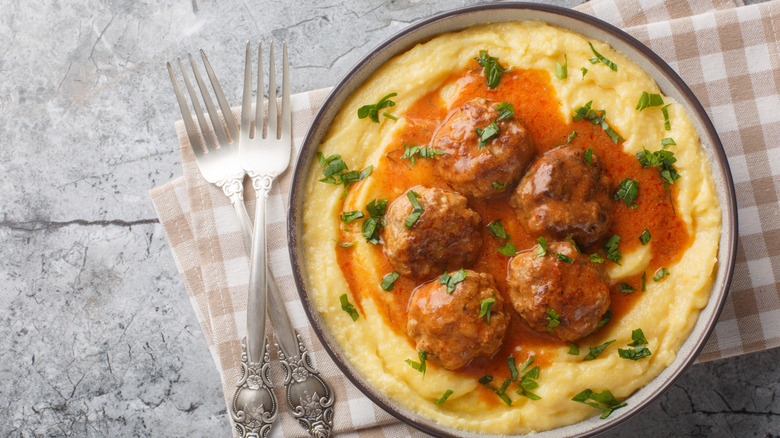 a plate of meatballs and gravy over mashed potatoes