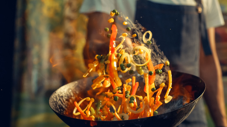 chef tossing ingredients in a wok