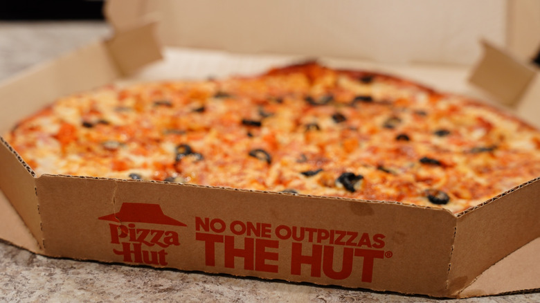 A Pizza Hut pizza sits in its box