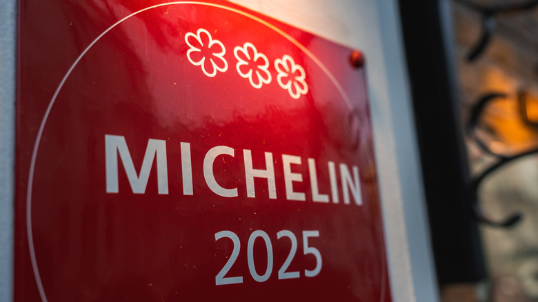 A red Michelin star sign hanging on a wall.