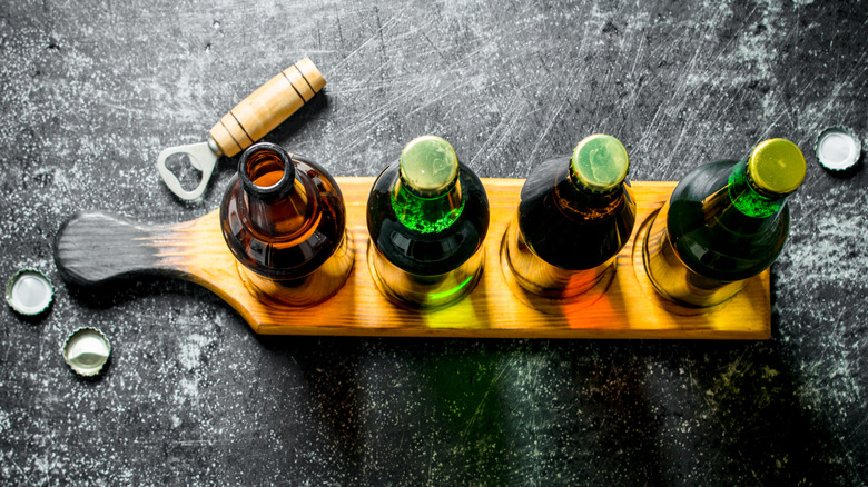Top view of bottled beers positioned on a wood serving board