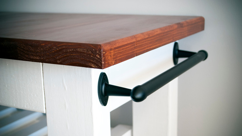 A mobile kitchen island with a tea towel rail installed