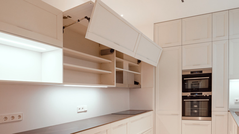 A mostly white kitchen with lift-hinge cabinets