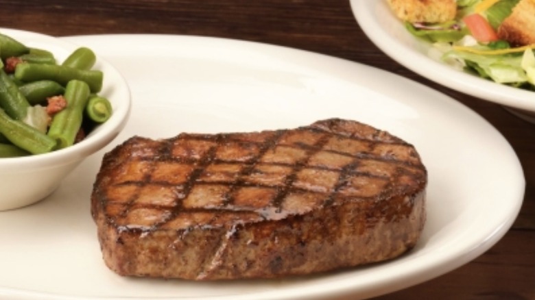 Sirloin steak with crosshatch sear marks served with green beans and a salad