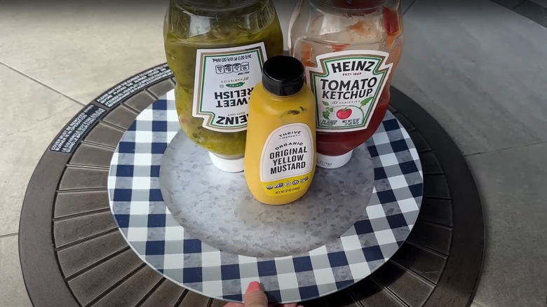 A DIY Lazy Susan has bottles of relish, ketchup, and mustard on it