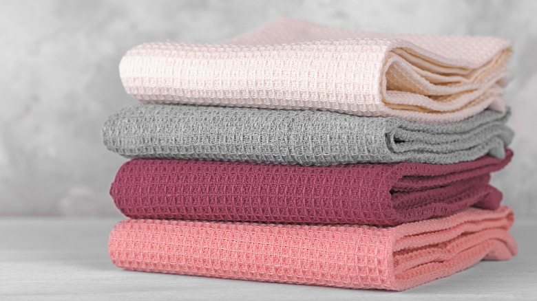 Stack of neatly folded kitchen towels in shades of pink and gray