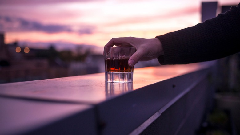 Person holding whiskey with no ice
