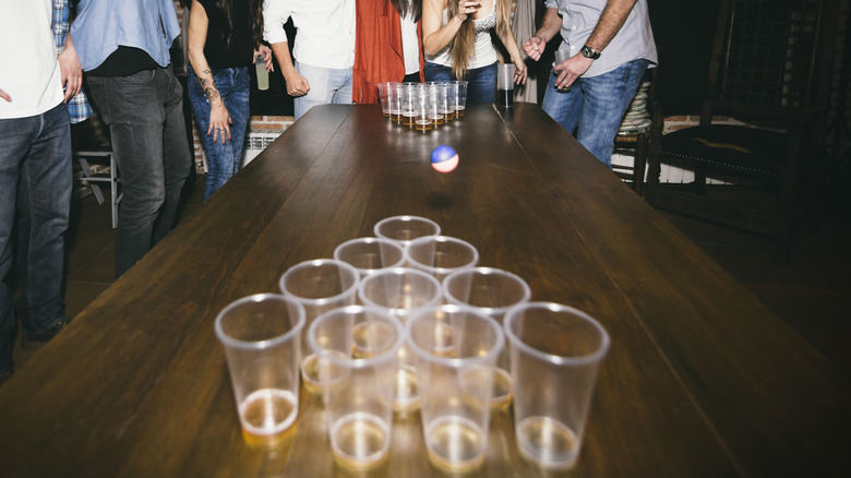 A group of young friends playing a game of beer pong