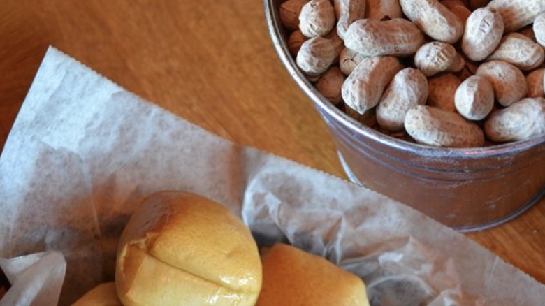 Bucket of peanuts beside a basket of rolls