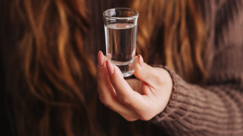 Woman holding a vodka shot