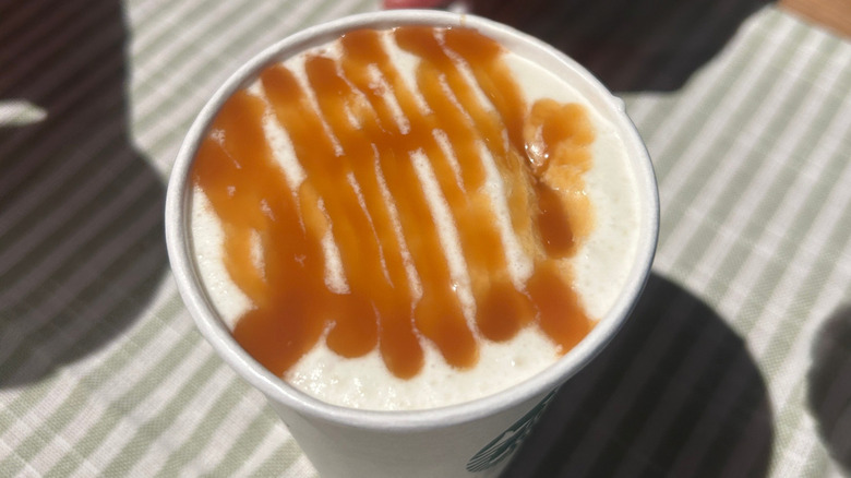 Overheat shot of Salted Caramel Mocha Strato Frappuccino on a green and white striped cloth