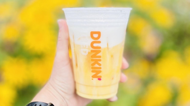 Hand holding new Mango Daydream Refresher from Dunkin'