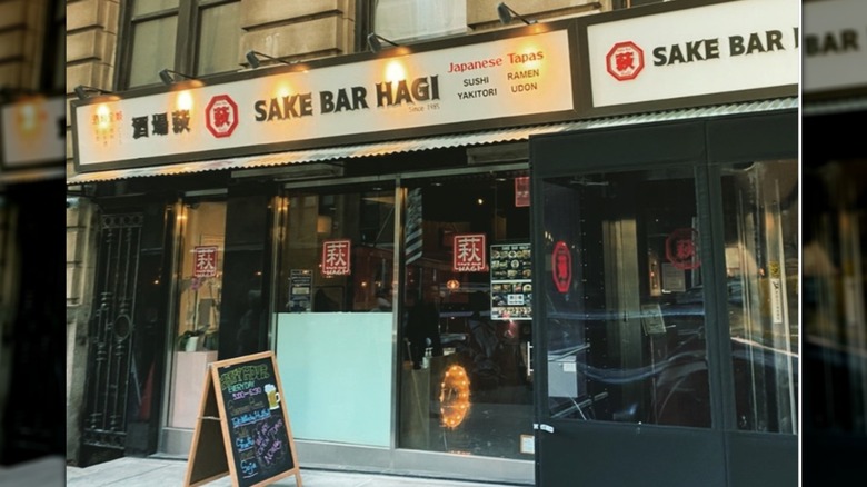 The exterior of Sake Bar Hagi, it has a white and black sigh above the door