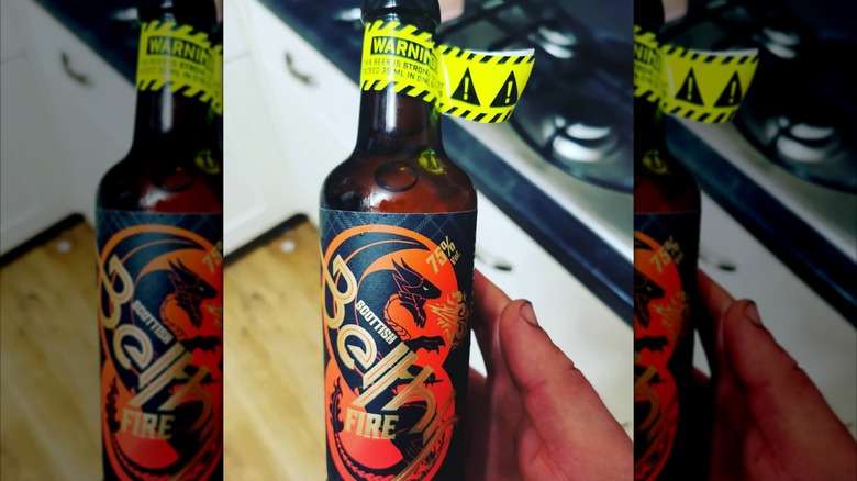 Hand holding a bottle of Scottish Beithir Fire beer