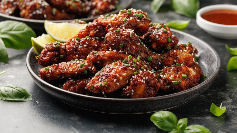 Platter of wings topped with chives and sesame seeds