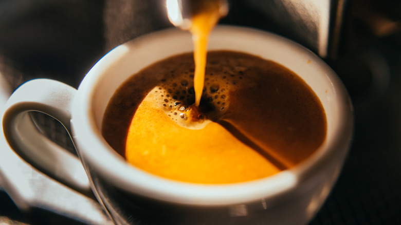 Fresh espresso shot pouring into a cup.
