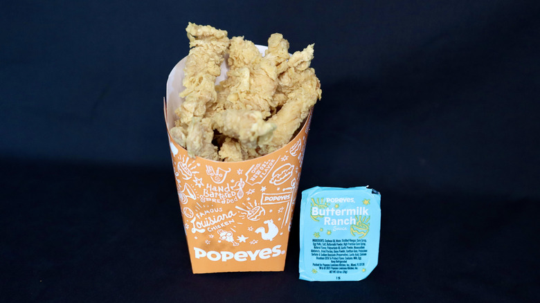 Popeyes chicken next to buttermilk ranch cup