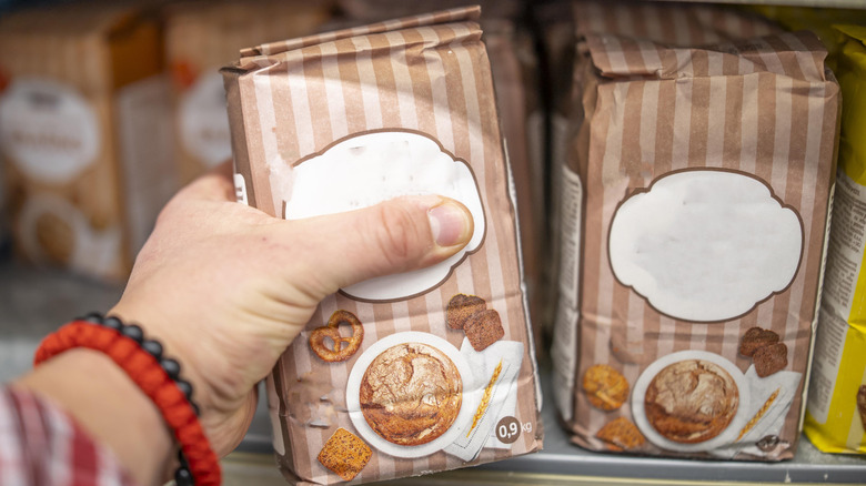 Woman selecting flour at grocery store