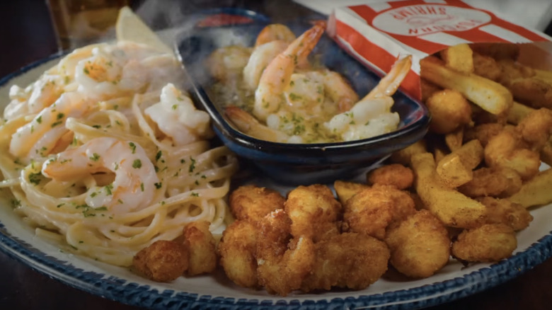 Platter with popcorn shrimp, garlic shrimp scampi, and shrimp linguini Alfredond