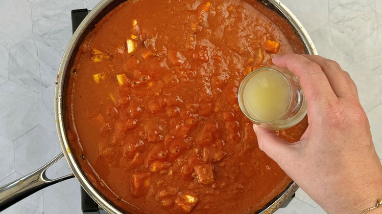 hand holding liquid over pan