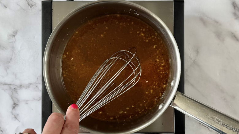 whisking orange sauce ingredients in saucepan