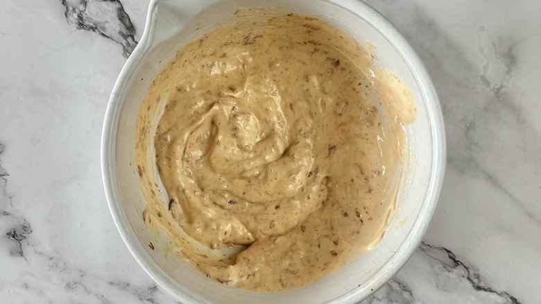 orange-colored dressing in a measuring cup