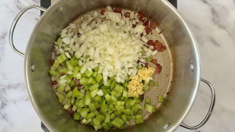 Chopped onion, celery, garlic, and bacon in soup pot