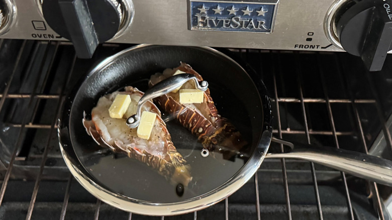 placing pan with lobster tails on oven rack