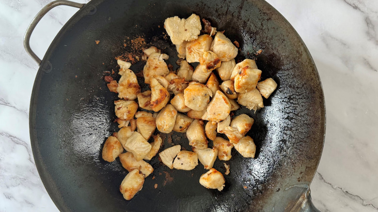 diced chicken browning in wok