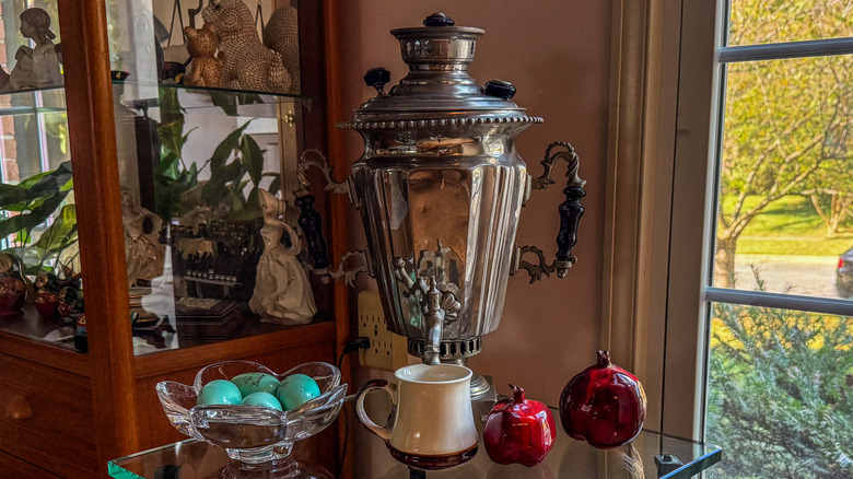 A brass tea samovar with a mug underneath it