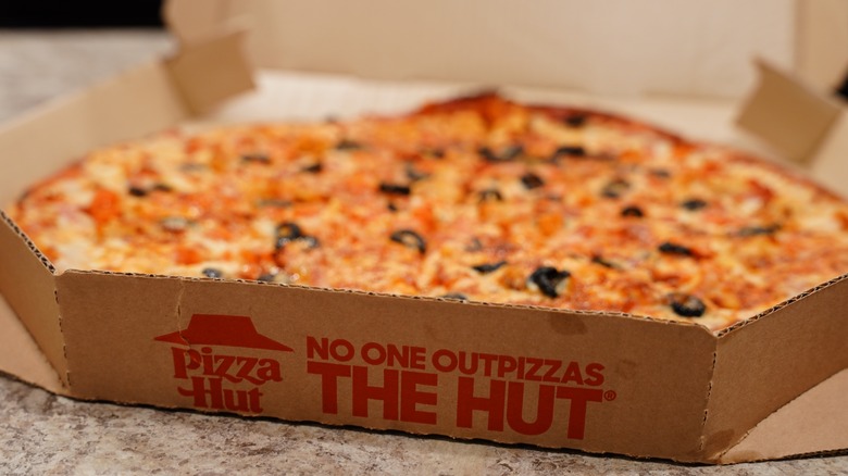 A Pizza Hut box that reads "No one outpizzas the hut"