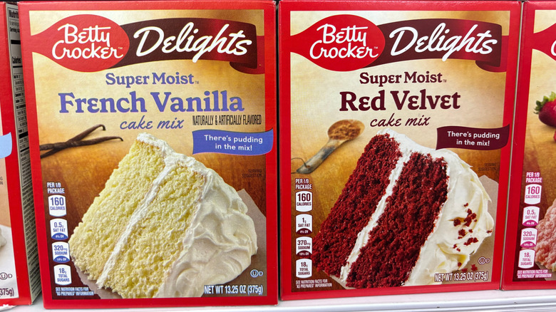 Different Betty Crocker boxed cake mixes lined up at store