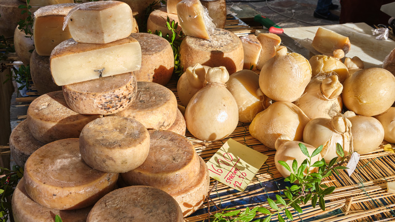 Wheels of casu marzu being sold in Sardinia along with other cheeses.