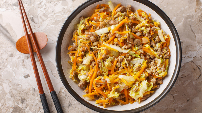 Up close shot of egg roll in a bowl with chopsticks