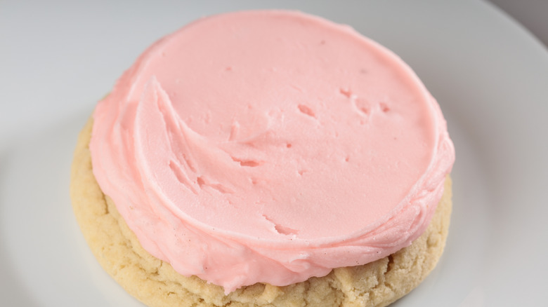 A thick, pink sugar cookie with a classic swoop design