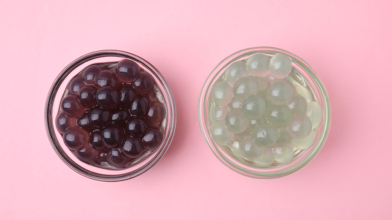 Two bowls of tapioca pearls sit on a pink background